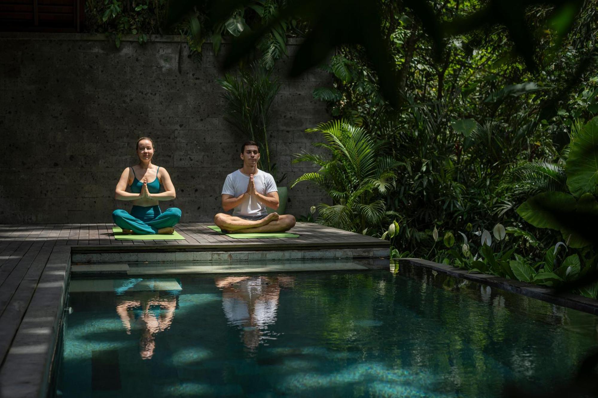 Отель Adiwana Suweta Убуд Экстерьер фото A couple practicing yoga at the Bvlgari Spa